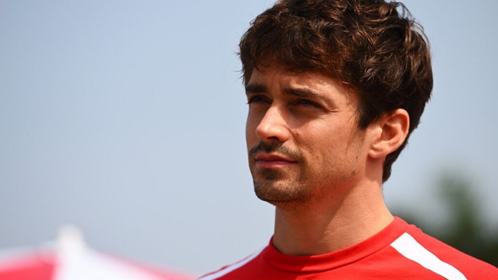 Шарль Леклер на фоні логотипу Ferrari
